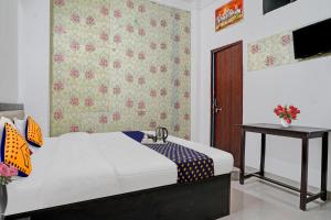 1 dormitorio con 1 cama y una pared con flores en SPOT ON Hotel Srb, en Jodhpur