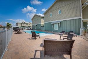 a patio with chairs and a pool next to a building at Bright, Modern Corpus Christi Condo 2 Mi to Beach in Padre Island