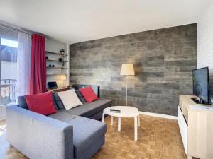 een woonkamer met een bank en een tv bij Appartement chic proche de Paris, parking inclus in Saint-Maur-des-Fossés