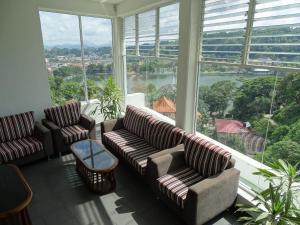 a living room with couches and a large window at Kandy Supreme Hotel in Kandy