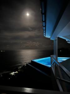 a night view of the ocean from a cruise ship at Villa Club Tropicana Carana with infinity pool in Machabee
