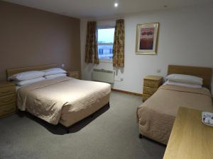 a hotel room with two beds and a window at The Sandringham Hotel in Weston-super-Mare