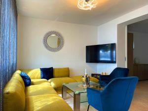 a living room with a yellow couch and a table at Villa Olivija-direkt am Strand! in Stara Novalja