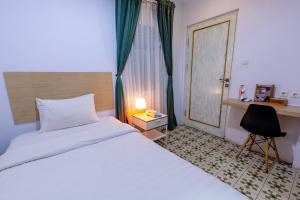 - une chambre avec un lit, un bureau et une chaise dans l'établissement BELVA huis, à Bogor