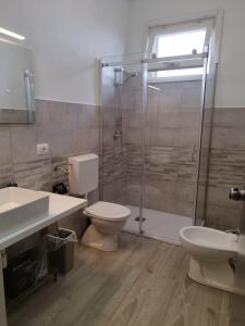 y baño con ducha, aseo y lavamanos. en b&b Casa Balai 72 a 150 mt dal mare, en Porto Torres