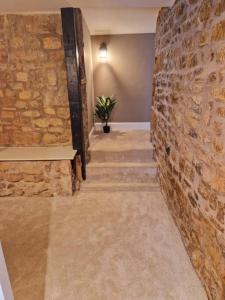 a hallway with a stone wall and a staircase at Hamilton - Lord William in Scorton