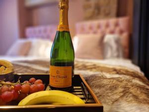 Una botella de champán junto a una bandeja de fruta. en Hamilton - Lord William, en Scorton