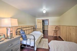 a bedroom with a bed and a desk and a chair at Danbury Cabin with Wraparound Porch on Lang Lake! in Danbury