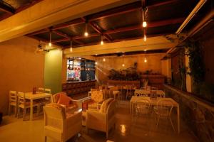 a restaurant with tables and chairs and a bar at BELVA huis in Bogor
