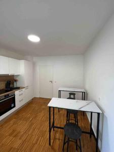 uma cozinha com uma mesa e dois bancos num quarto em Sunset Dreams Apartment em Bühl