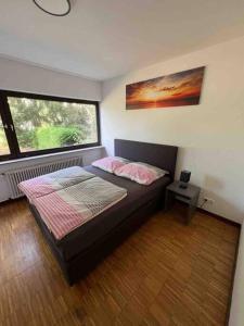 um quarto com uma cama e uma grande janela em Sunset Dreams Apartment em Bühl