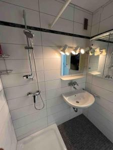 a white bathroom with a sink and a mirror at Sunset Dreams Apartment in Bühl