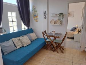 Una sala de estar con un sofá azul y una mesa. en New Apartment Europa 2, en El Médano