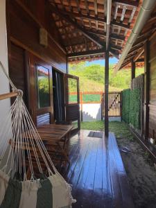 a porch of a cabin with a hammock on it at Chalés Paradise in Atins