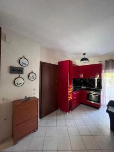 a kitchen with red cabinets and a stove at Καλλιθεα in Kallithea Halkidikis