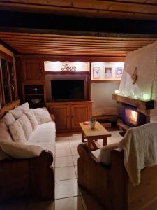 a living room with two couches and a television at Chalet de Manigod in Manigod