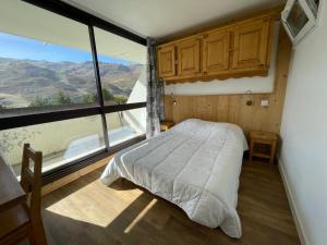ein Schlafzimmer mit einem Bett und einem großen Fenster in der Unterkunft Appartement Les Menuires, 2 pièces, 4 personnes - FR-1-452-270 in Les Menuires