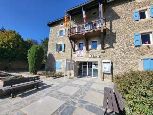 a building with two benches in front of it at Precioso Apartamento en Osséja in Osséja