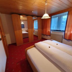 ein Schlafzimmer mit 2 Betten in einem Zimmer mit Spiegel in der Unterkunft Pitztal Ferienwohnungen in Sankt Leonhard im Pitztal