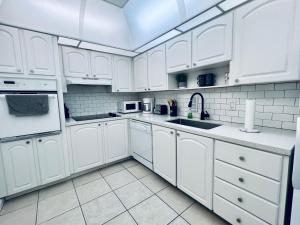 a white kitchen with white cabinets and a sink at Oceanview Beachfront Condo on Tides Resort in Hollywood