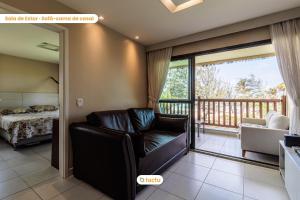 ein Wohnzimmer mit Couch und Balkon in der Unterkunft Bangalô vista mar no VG Sun Cumbuco por Tactu in Paracumbuca + 52 Fotos