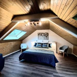 a bedroom with a large bed in a attic at Au Repos du Fayé in Grosmagny