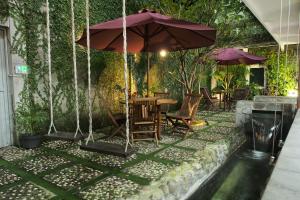 a patio with an umbrella and a table and chairs at BELVA huis in Bogor