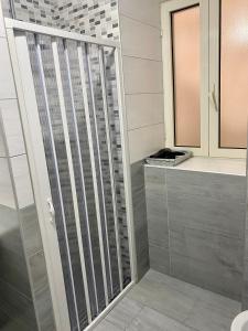 een douche met een glazen deur in de badkamer bij Figurari Home Napoli-3 Deluxe in Napels