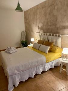 een slaapkamer met een groot wit bed met gele kussens bij Figurari Home Napoli-3 Deluxe in Napels