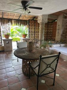 een patio met een tafel en stoelen en een plafondventilator bij Casa Miura Hotel Boutique in Ajijic