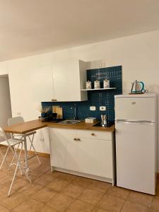 een keuken met een witte koelkast en een tafel bij Figurari Home Napoli-3 Deluxe in Napels