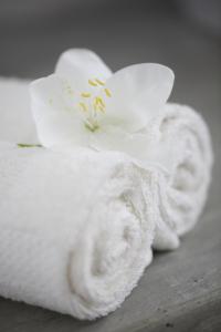 a white towel with a flower on top of it at Stone Well Garden Villa in Hikkaduwa