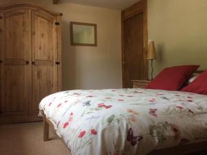 a bedroom with a bed with a floral comforter at Afon Duad Inn and Dolau Cottage in Cwm-Duad