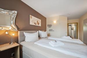 um quarto de hotel com duas camas e um espelho em 7o'Clock - Hannover Laatzen em Hanôver