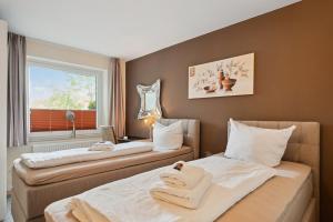 Duas camas num quarto com uma janela em 7o'Clock - Hannover Laatzen em Hanôver