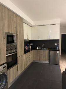 a kitchen with white cabinets and a stainless steel appliance at Zena Park in Odivelas