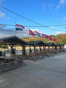 una fila de mesas de picnic con banderas. en Grand Atakum Boutıque Hotel en Mahmutlu