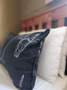 a black pillow sitting on top of a bed at Grootwaterval Guest Farm in Prince Albert +173 photos