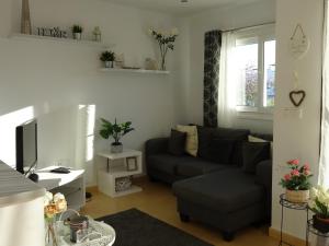 uma sala de estar com um sofá e uma televisão em Jardin 566 em Alhama de Múrcia