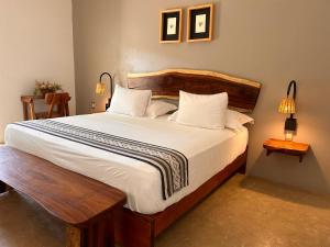 sypialnia z dużym łóżkiem z białą pościelą i poduszkami w obiekcie Hotelito Zicatela Cam a la Cruz 70938 Puerto Escondido Oax w mieście Brisas de Zicatela