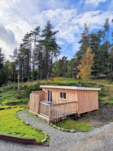 a small wooden building on a hill with trees at Kaoglen Lodge - Fawn Pod - Hot Tub - Dogs - Pitlochry - Luxury in Blairgowrie