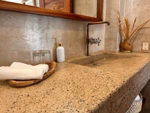 - un comptoir de salle de bains avec un lavabo et une bouteille de savon dans l'établissement Hotelito Zicatela Cam a la Cruz 70938 Puerto Escondido Oax, à Brisas de Zicatela
