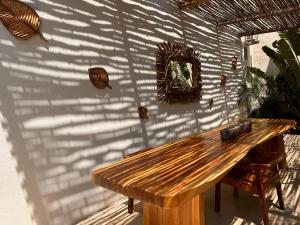 - une table en bois sur une terrasse avec un mur dans l'établissement Hotelito Zicatela Cam a la Cruz 70938 Puerto Escondido Oax, à Brisas de Zicatela