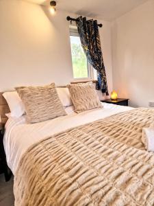 1 dormitorio con 1 cama grande y ventana en Kaoglen Lodge - Fawn Pod - Hot Tub - Dogs - Pitlochry - Luxury, en Blairgowrie