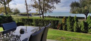 a table and chairs with a view of the water at Panoráma Gold Wellness Apartman in Siófok