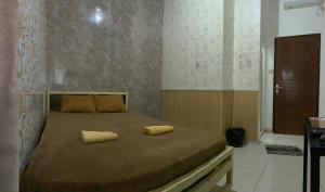a bedroom with a bed with two yellow pillows on it at Butterfly Kost Tulungagung in Ngantru +30 photos