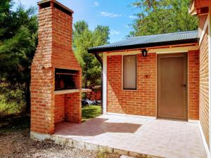 a brick building with a door and a patio at Cabaña Ángeles del Bosque 5 in Villa Ciudad Parque