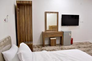 a bedroom with a bed and a mirror and a television at فندق نجران ول ان in Najran