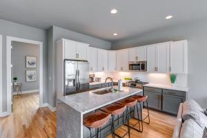 a kitchen with white cabinets and a large island with bar stools at Nashville Townhome with Rooftop Balcony and Game Room! in Nashville