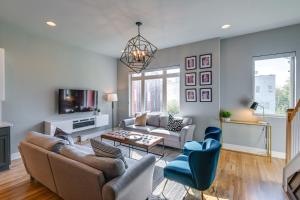 a living room with a couch and chairs and a tv at Nashville Townhome with Rooftop Balcony and Game Room! in Nashville
